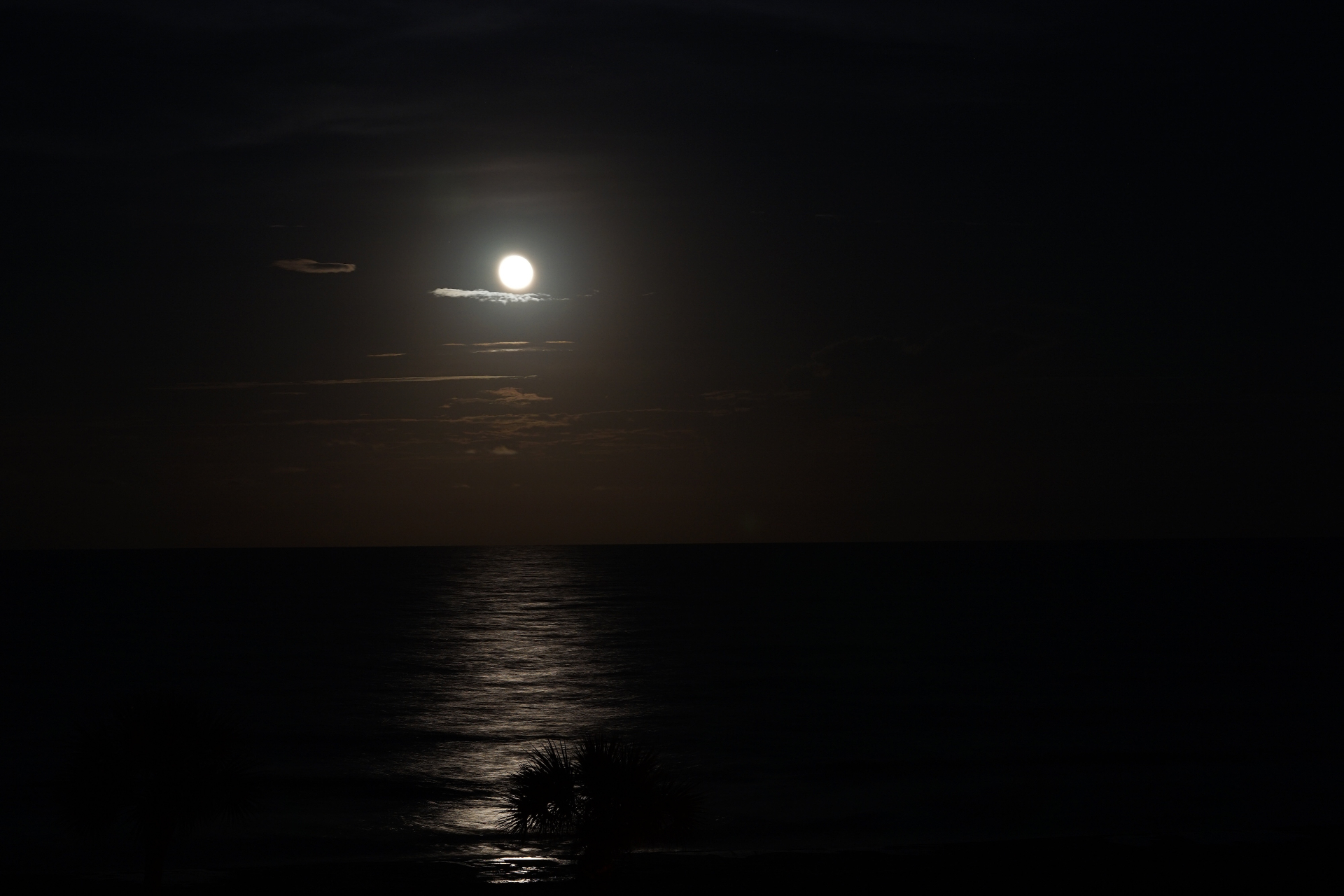 Full moon rising over the Atlantic Ocean with light reflecting on water
